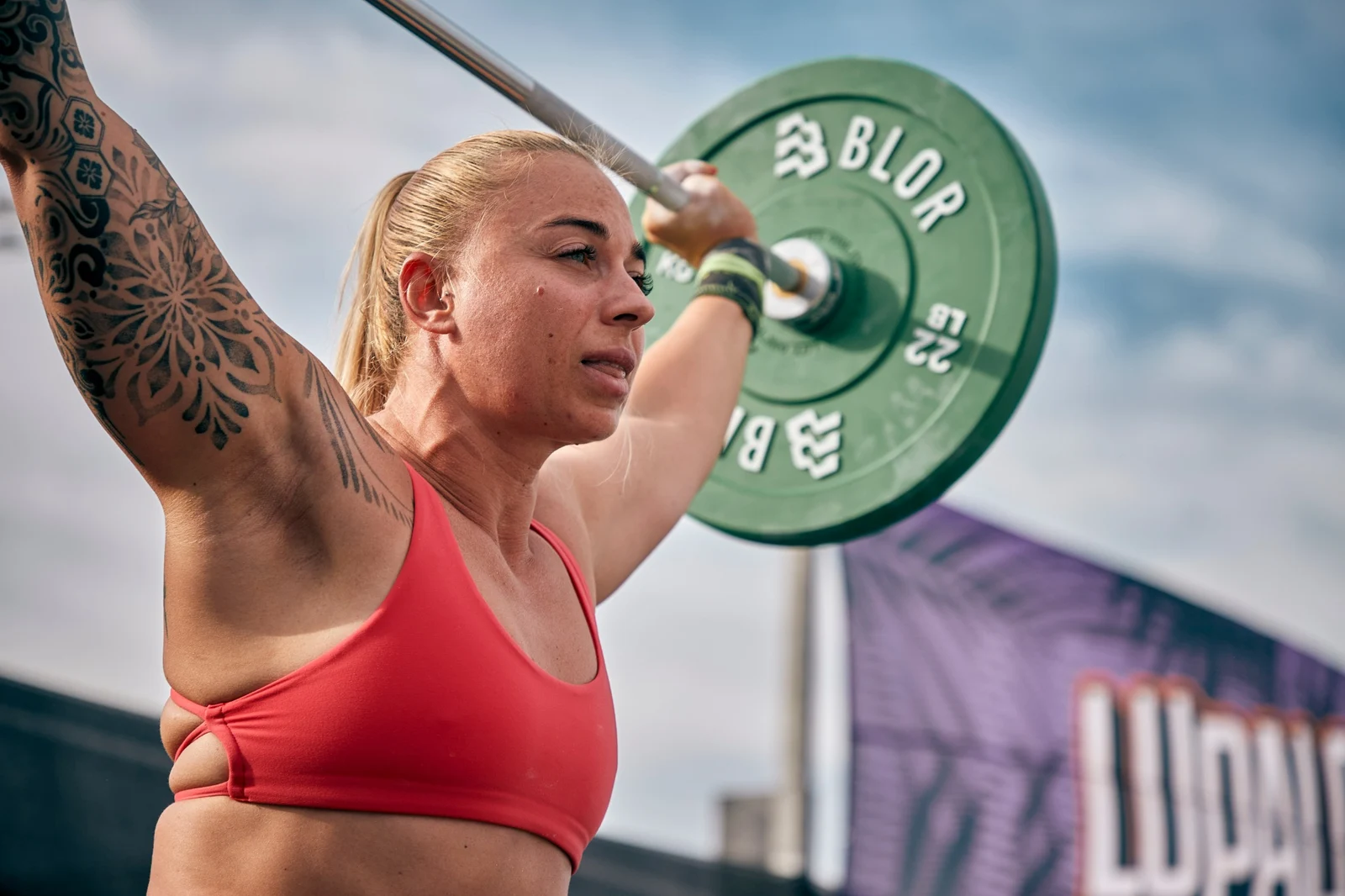 Laura súlyemelő gyakorlat közben, fej fölé emelt rúddal